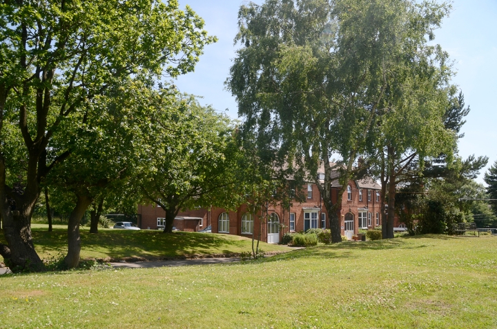 School building with trees and green grass in front.